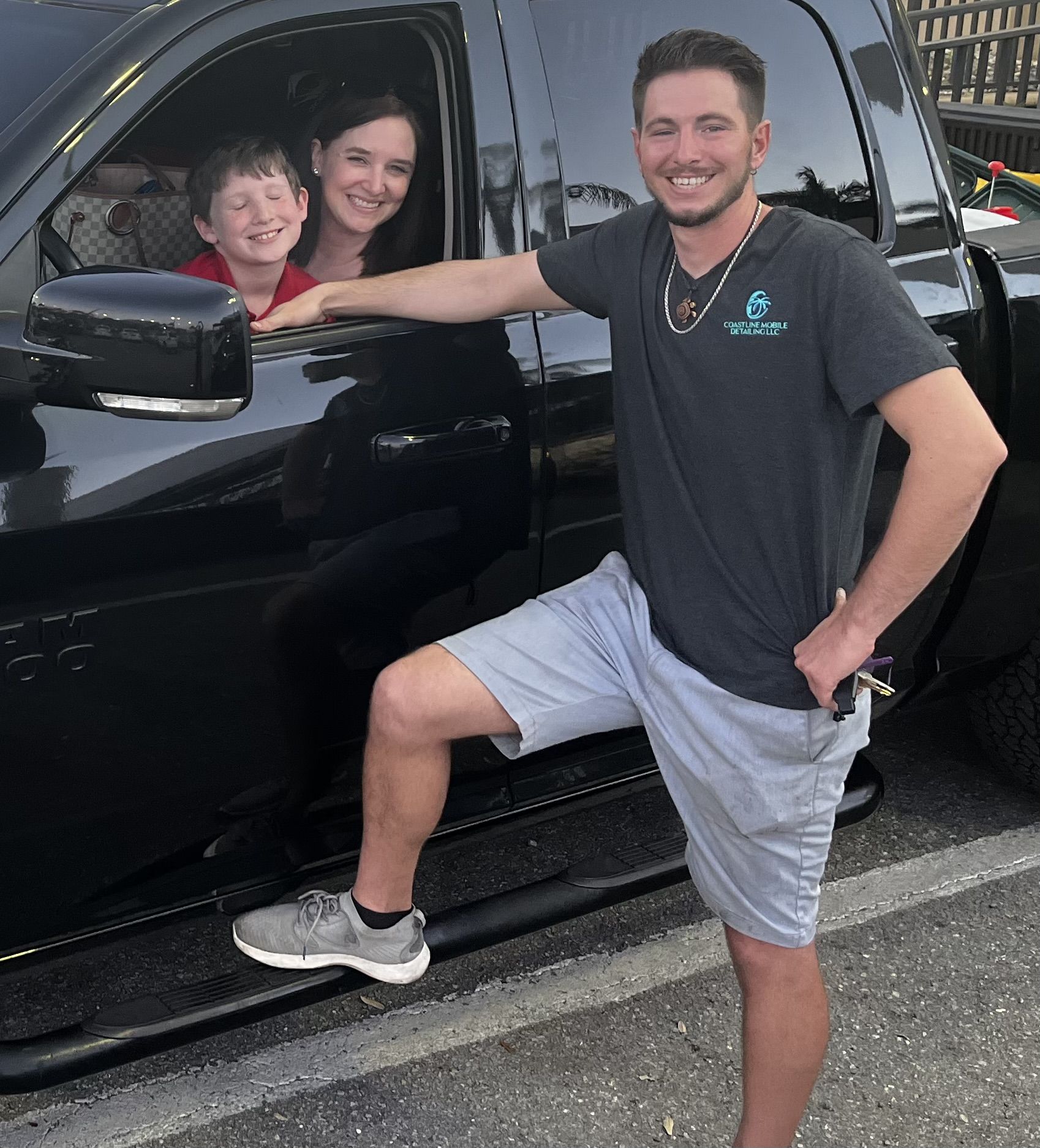 Ian Peterson and his family standing beside a black RAM truck