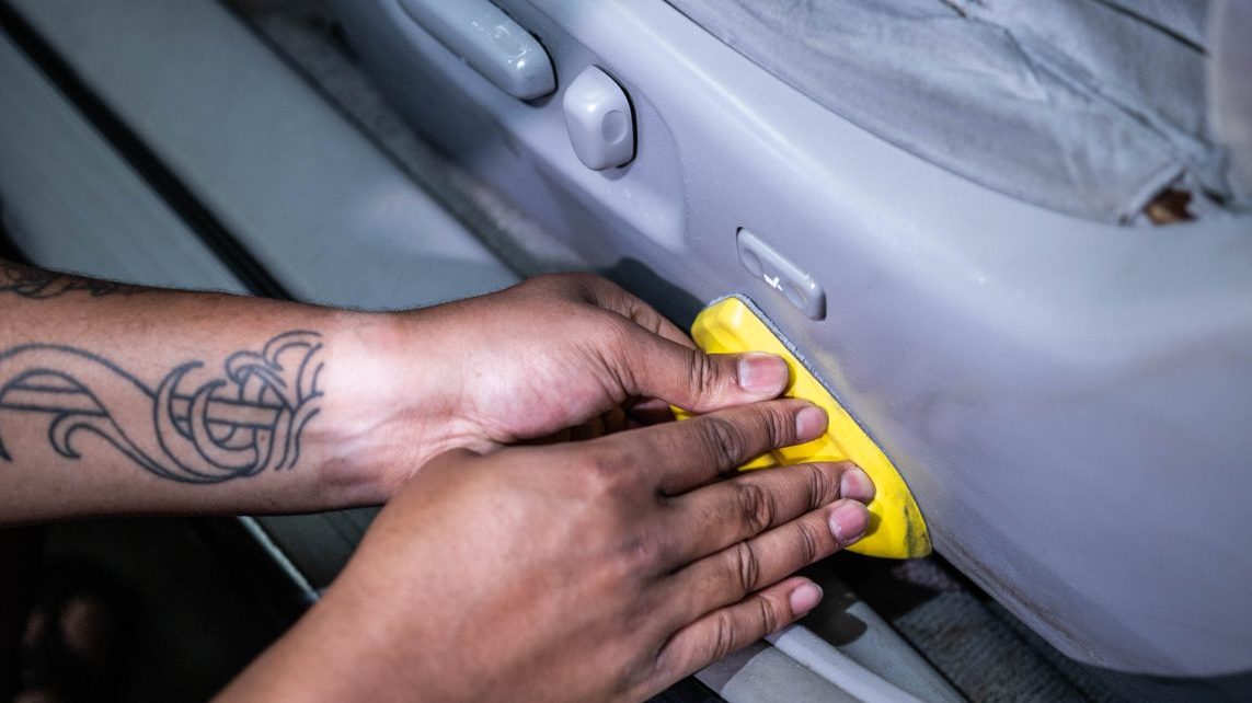 Hand-scrubbing a seat bolster during an interior deep clean