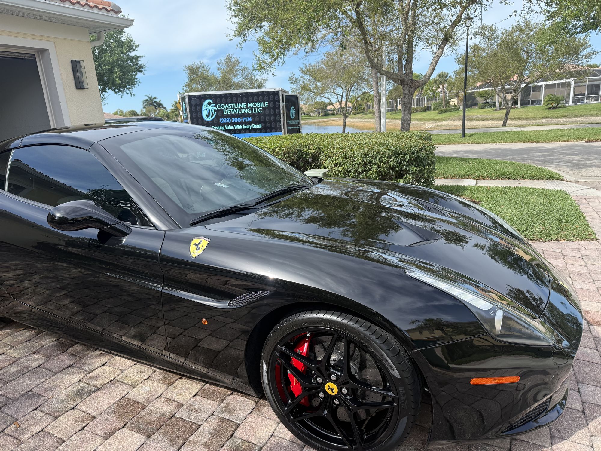 Black Ferrari California with a deep gloss finish after detailing in a gated Naples community